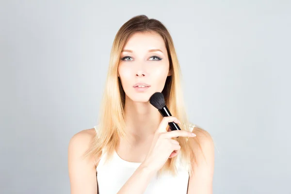 Blonde woman holding professional brush for blush. Make up artist. — Stock Photo, Image