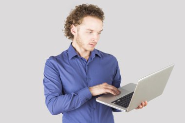Akıllı bir adam bir şey üstünde laptop Studio gri arka plan üzerine yazarak. Modern yaşam tarzı.