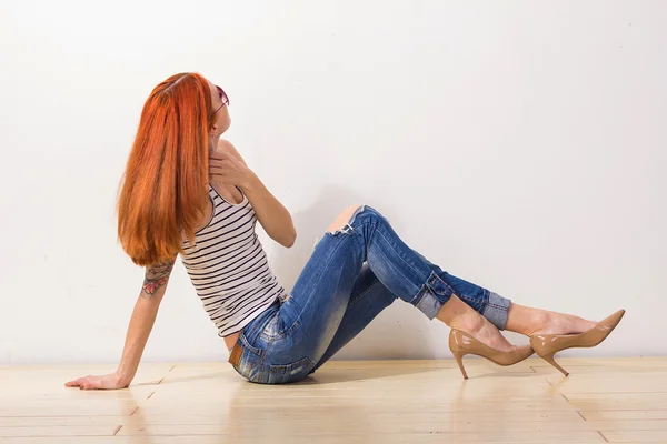 Roodharige vrouw met tatoeage aanraken haar mooie haren — Stockfoto
