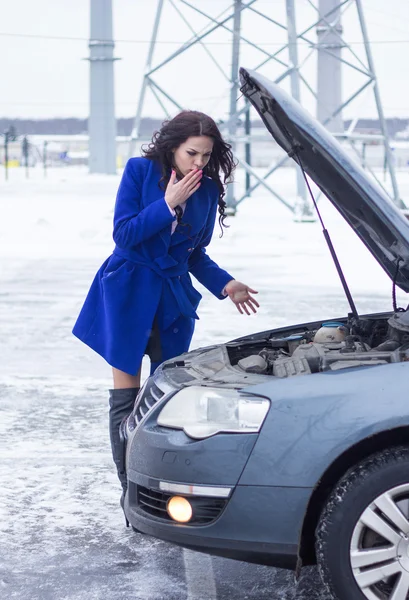 Überraschte Frau schaut unter die Motorhaube der kaputten Maschine — Stockfoto