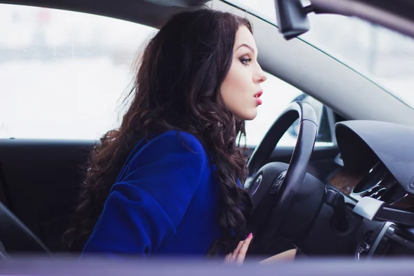 Mädchen blickt nachdenklich in die Windschutzscheibe des Autos — Stockfoto