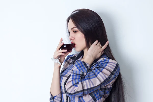 Jonge vrouw streelde haar haren en het drinken van rode wijn — Stockfoto