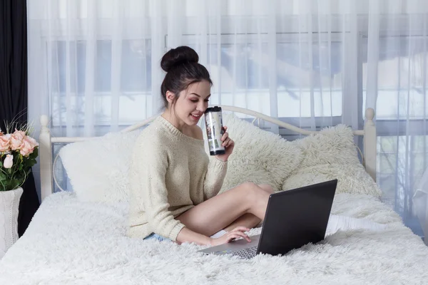 Lachende junge Frau liest etwas Interessantes auf dem Laptop — Stockfoto