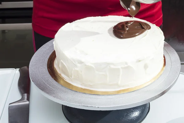 녹 인된 초콜릿으로 케이크를 부 어 시작 하는 여자 — 스톡 사진