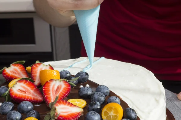 Kadın krema makinesi üzerinden tarafından bir pasta Süsle — Stok fotoğraf