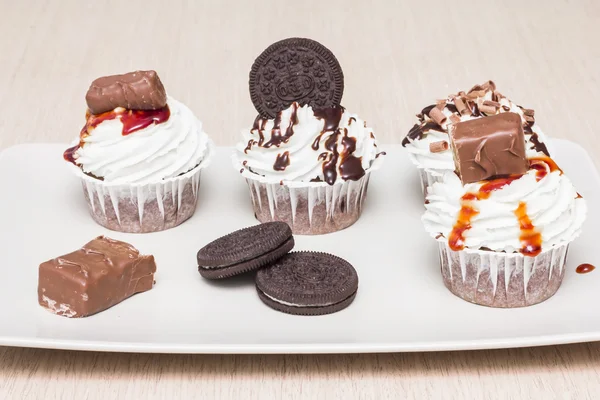 Bisküvi ve çikolata bir plaka ile farklı lezzetli cupcakes