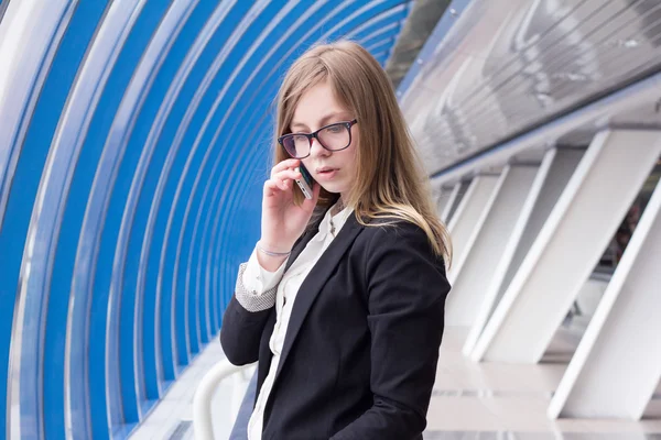Jovem mulher de negócios falando ao telefone no centro de negócios — Fotografia de Stock