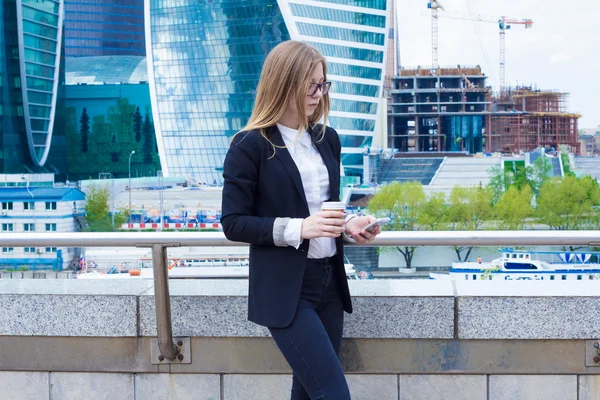 Young business woman with coffee corresponds with the customer on the phone on the street — Stock Photo, Image