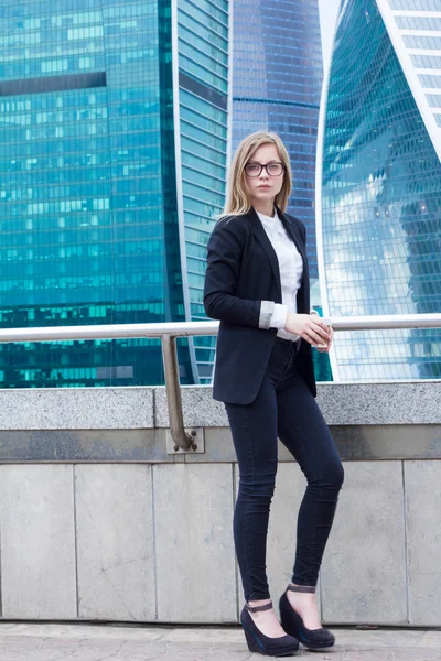 Business woman standing with coffee in hand on the background of skyscrapers — Stock Photo, Image