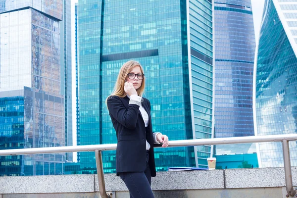 Atraktivní obchodní žena na pozadí mrakodrapů na telefonu — Stock fotografie