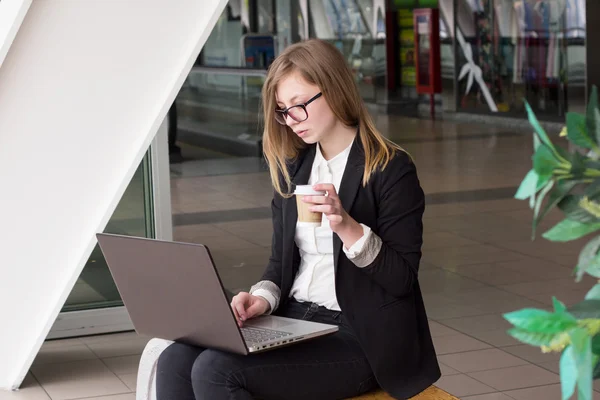 Fiatal üzleti nő egy laptop kávéfogyasztás — Stock Fotó