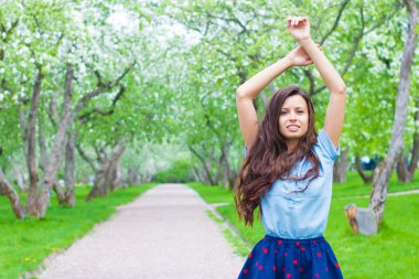 Neşeli kadın kıvırcık kalın saçlı parkta gülüyor
