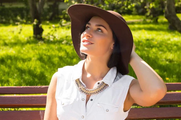 Portrait d'une jolie femme qui sent le chapeau dans le parc par une journée ensoleillée — Photo