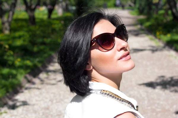 Humeur estivale. Portrait d'une femme en lunettes de soleil au parc — Photo