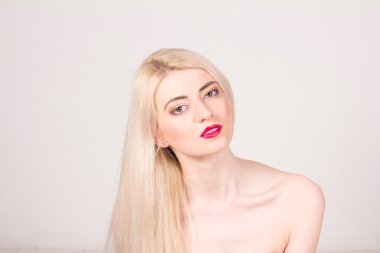 moda model stüdyoda poz. güzel bir kadınla uzun düz sarı saçlı, kırmızı dudaklar ve makyaj