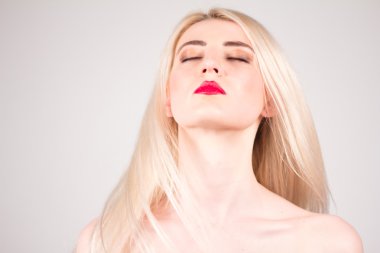 Blonde with flying hair, closed eyes and make-up. Beauty concept.