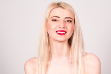 Blonde woman with red lips, make-up and smile with teeth. Beauty concept.