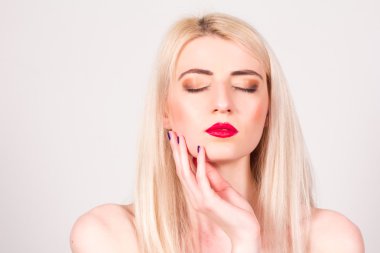 Blonde woman with closed eyes and with a manicure in the studio. Manicure.