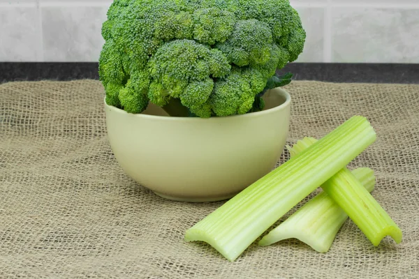 Verduras frescas. brócolis inteiro em uma tigela com aipo na toalha da mesa — Stockfoto