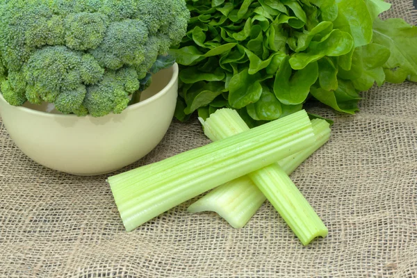 Verduras frescas. brócolis inteiro em uma tigela com alface e aipo na toalha da mesa — Stockfoto
