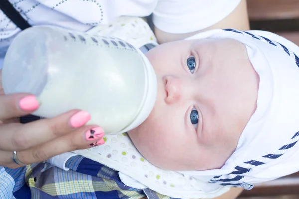 La mamma nutre il bambino con una bottiglia per strada — Foto Stock