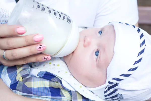 La mamma nutre il bambino con una bottiglia per strada — Foto Stock