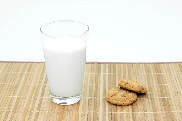 Cookies och ett glas mjölk på en bambu duk — Stockfoto