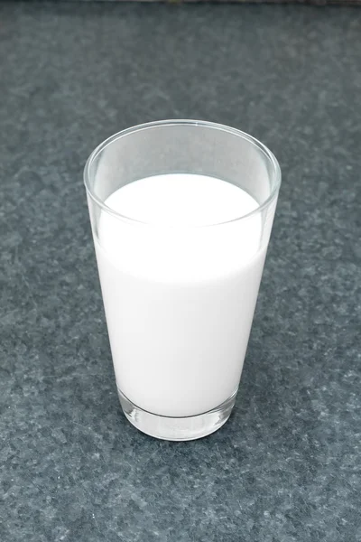 Vaso lleno de leche sobre la mesa —  Fotos de Stock