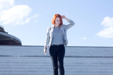 Kızıl saçlı çekici kadın tablet ile merdivenlerden aşağı