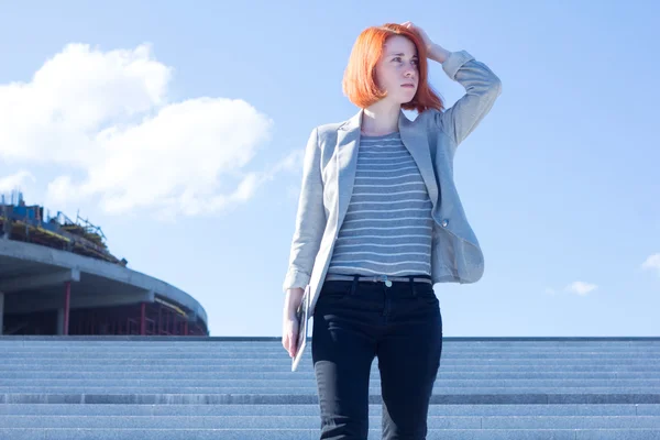 Redhead attractive woman down the stairs with tablet — Stock Photo, Image