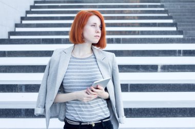 İş kadını elinde bir yana iş merkezi merdivenlerde arka plan üzerinde arıyorsunuz bir tablet ile