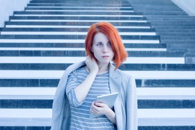 İş kadını elinde bir yana iş merkezi merdivenlerde arka plan üzerinde arıyorsunuz bir tablet ile