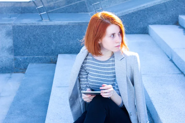 Portrait of a woman looking to the side with the tablet — Stock Photo, Image