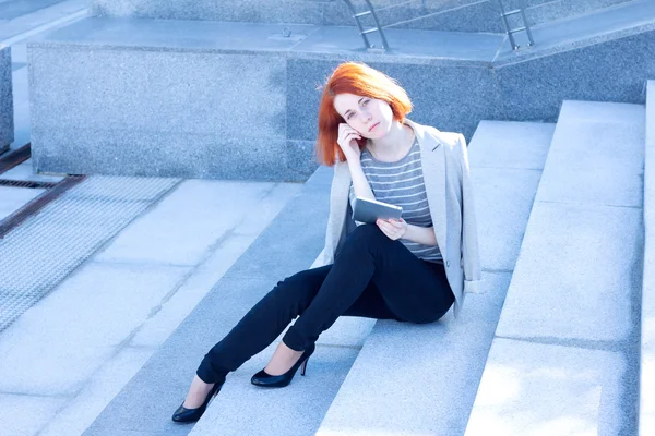 빨강 머리 매력적인 여자 태블릿 밖 계단에 앉아 — 스톡 사진