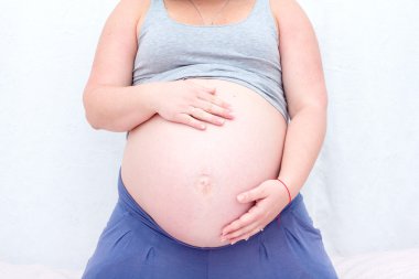 Karın hamile bir kadının. Hamile kadın göbeğine dokunmak.