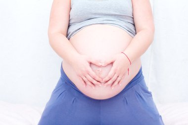 Karın hamile bir kadının. Hamile bir kadın kalp karnına gösterilen.