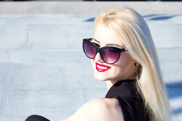 Portrait d'une femme blonde riante aux lèvres rouges en lunettes de soleil — Photo