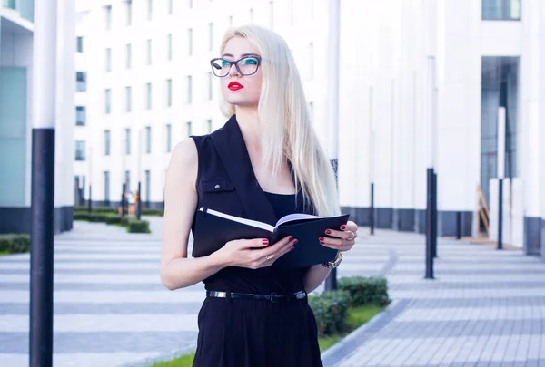 Porträt einer intelligenten Frau mit offenem Notizbuch auf dem Hintergrund des Business Centers — Stockfoto