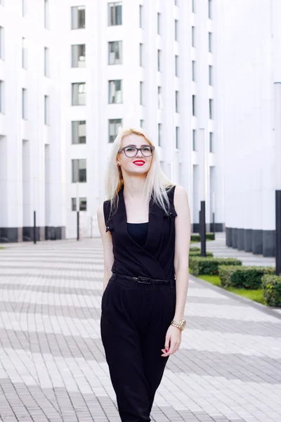 Sonriente mujer rubia inteligente en el fondo del centro de negocios . — Foto de Stock