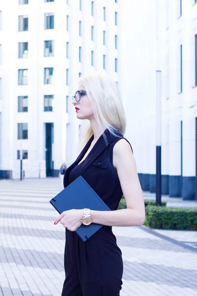 Ritratto di donna bionda intelligente con un taccuino sullo sfondo del business center . — Foto Stock