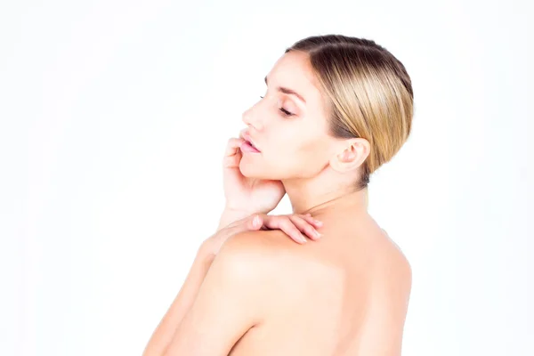 Jovem com pele bonita e costas nuas olhando para baixo e tocando seu rosto. Conceito de beleza . — Fotografia de Stock