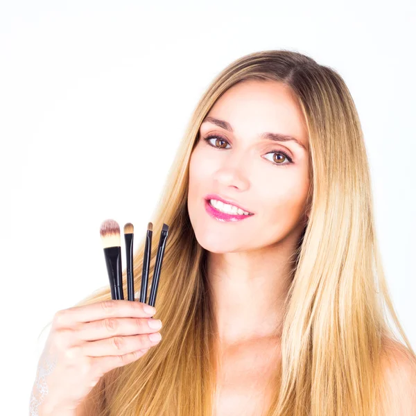 Jovem mulher feliz com sorriso está segurando escovas cosméticas. Make-u — Fotografia de Stock