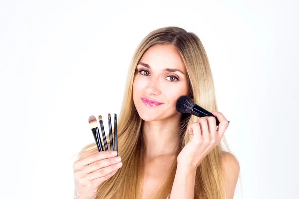 Mujer hermosa feliz aplicar rubor en la cara con sonrisa. Artista de maquillaje . —  Fotos de Stock