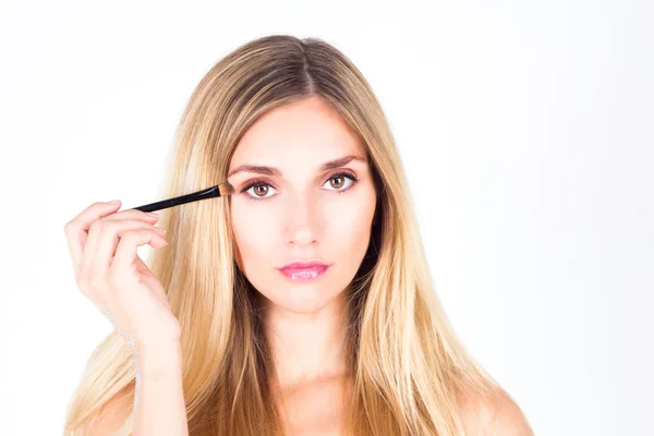 Schöne Frau malt Augenlid mit einem Kosmetikpinsel. Make-up. — Stockfoto