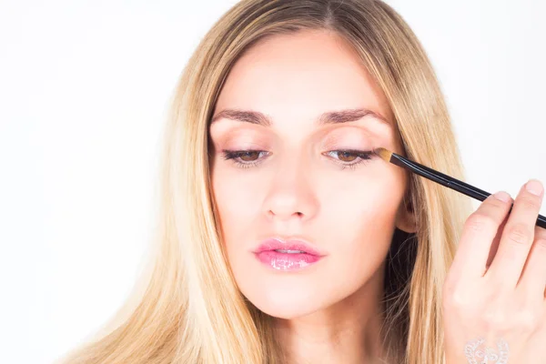 Beautiful woman looking down and apply shade on eyelid — Stock Photo, Image