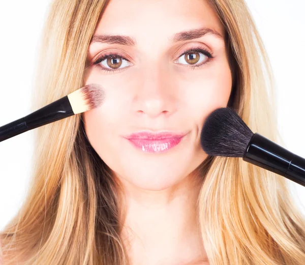 Maquiagem artista pinta uma mulher e corrige o tom de pele da mulher com escovas cosméticas — Fotografia de Stock