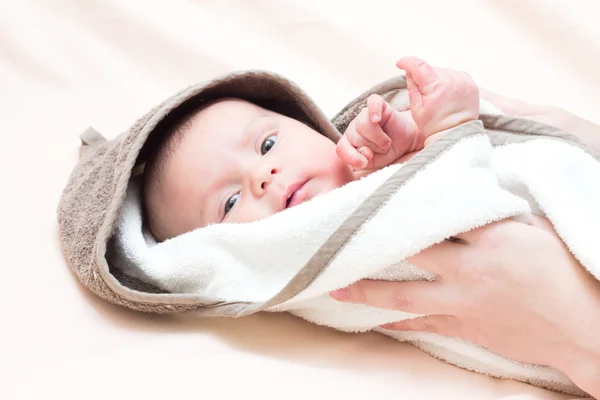 Bambino in un asciugamano e le mani della madre — Foto Stock