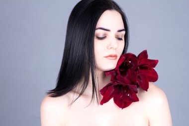 Güzel esmer ile kapalı gözler ve çiçek omzuna. Güzellik bakımı.