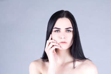 Yanağı el ile dokunmak ve düz görünümlü esmer kadın. Güzellik kavramı