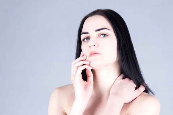 Mujer morena tocándose la mejilla a mano. Concepto de belleza —  Fotos de Stock